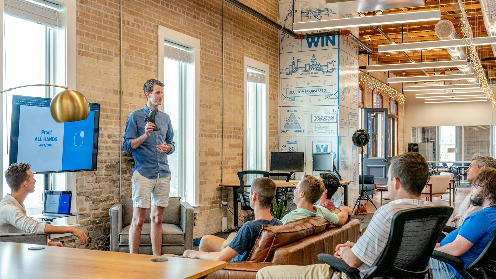 Business team attending an in-room AI training workshop with a presenter and screen.